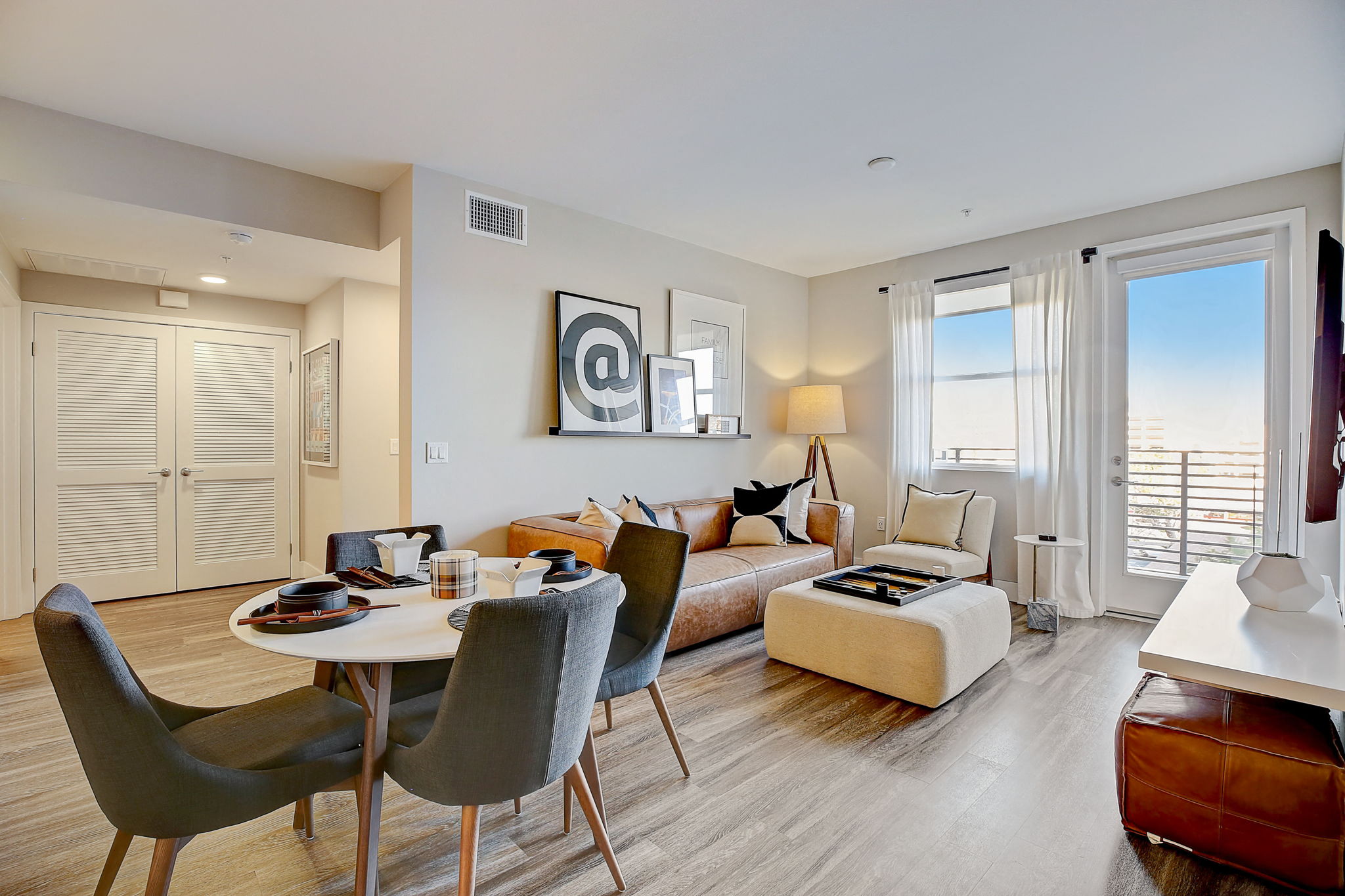 Contemporary living room featuring a stylish dining table with chairs, open floor plan, and modern decor at Eleven10,Spacious living room featuring a comfortable couch, dining table with chairs, and modern decor.